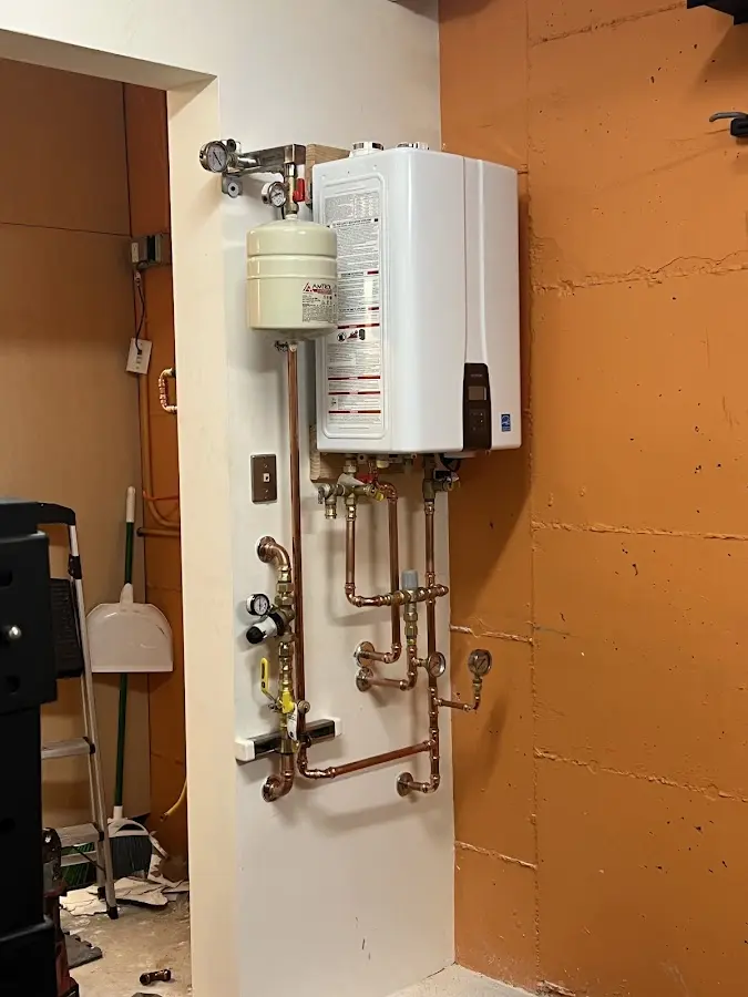 Plumbing technician inspecting water heater connections in Valley Park